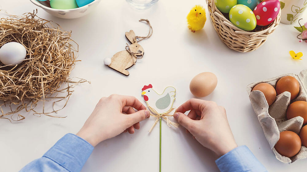 Person tying a toy chick with decorative band