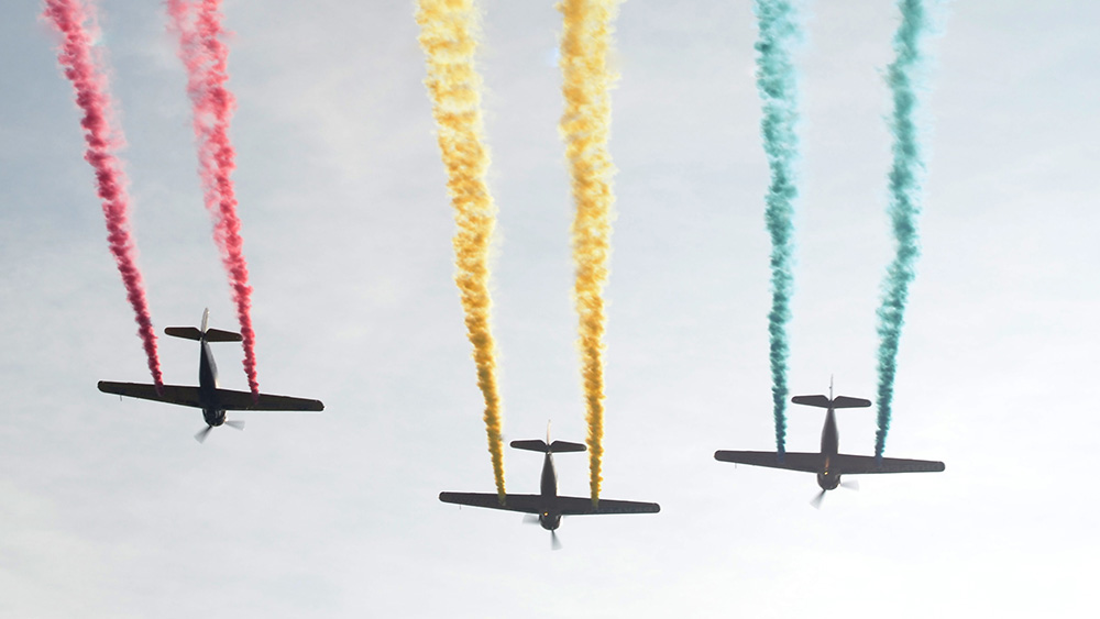 три летящи самолета изпускат трицветен дим