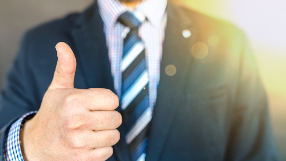 Man in business suit giving thumbs up