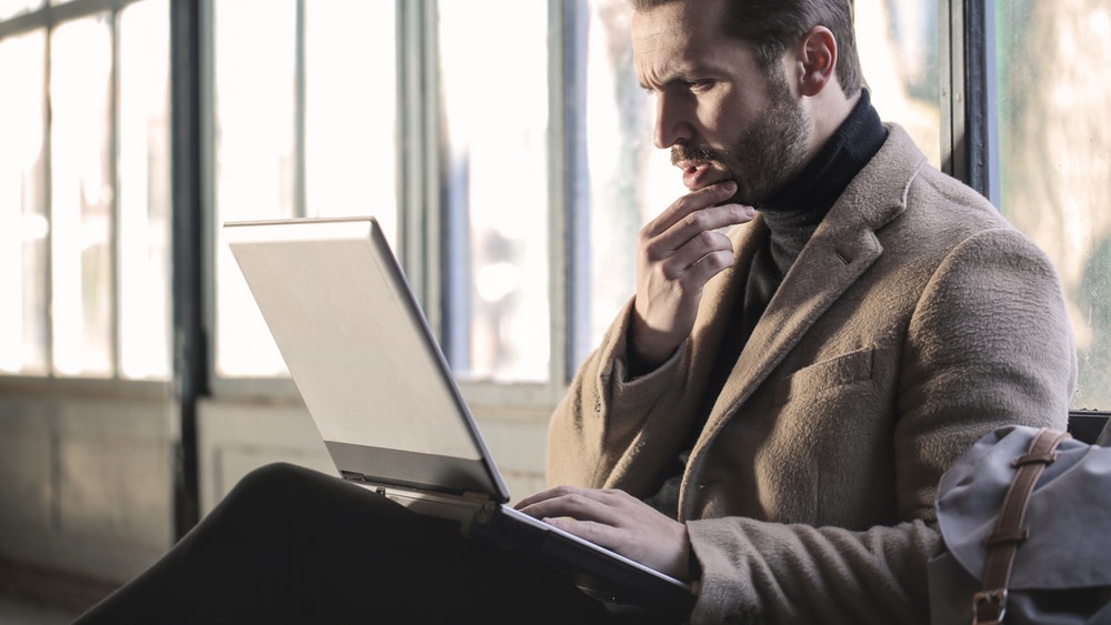 Pictured: confused-looking man with laptop.