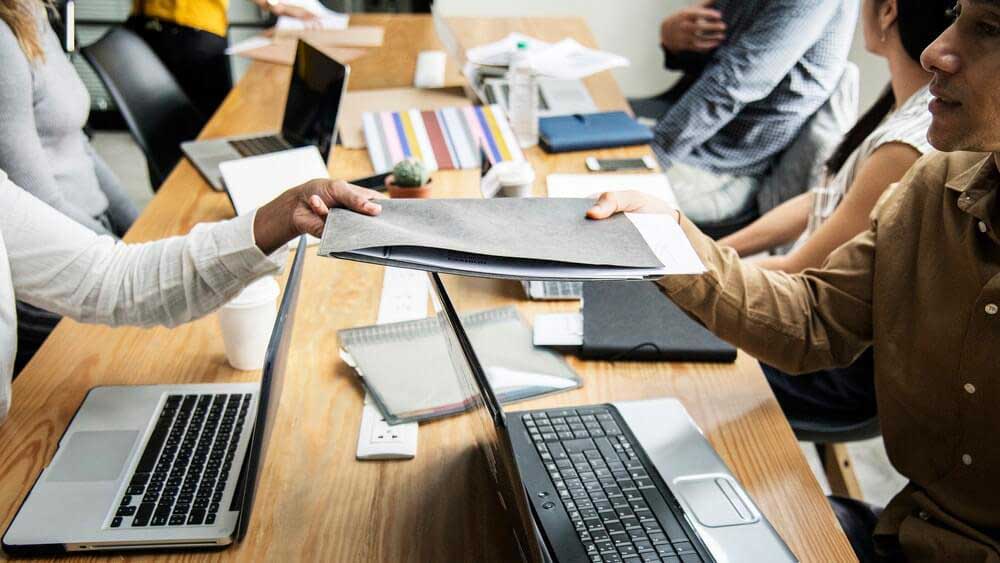 Pictured: multiple people sitting on desk