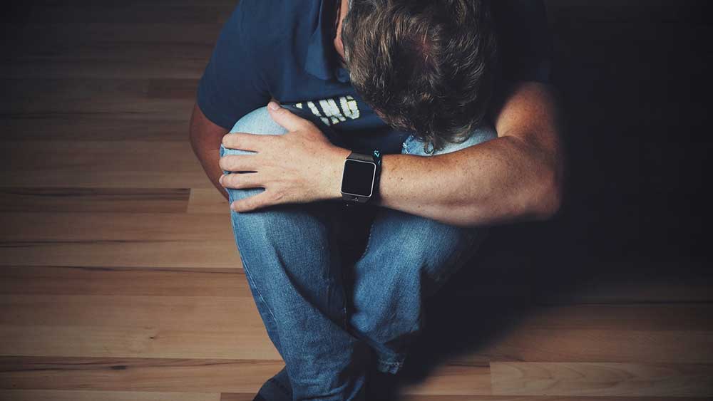 Sad person sitting on laminate flooring