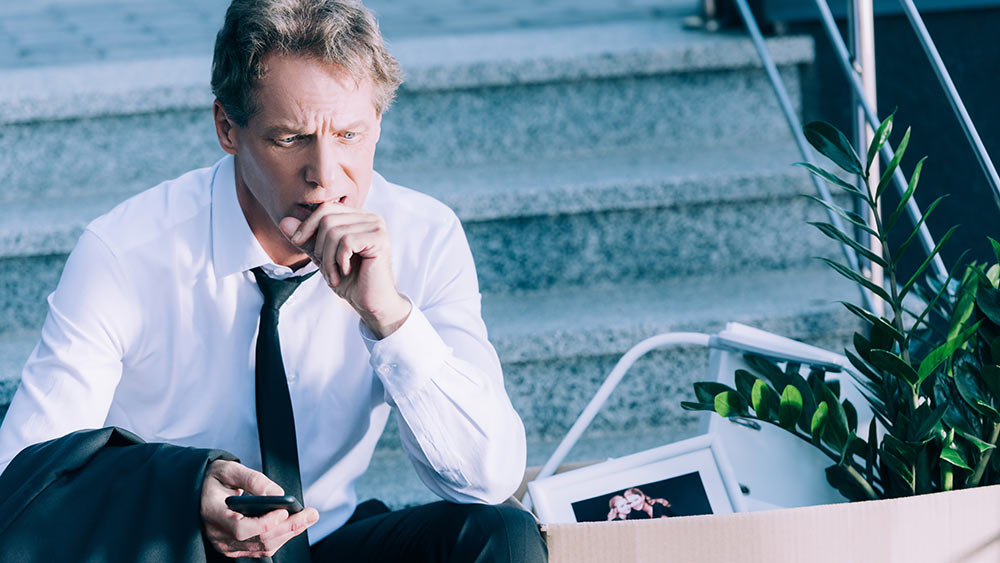 picture of worried man in a tie sitting on stairs