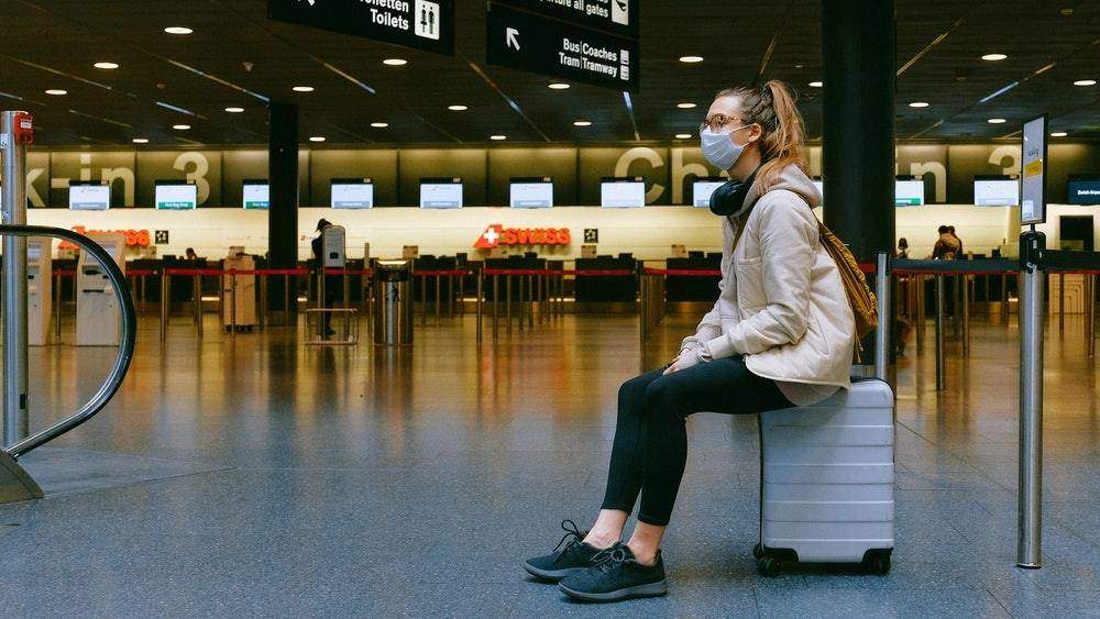 Girl sitting on luggage at airport