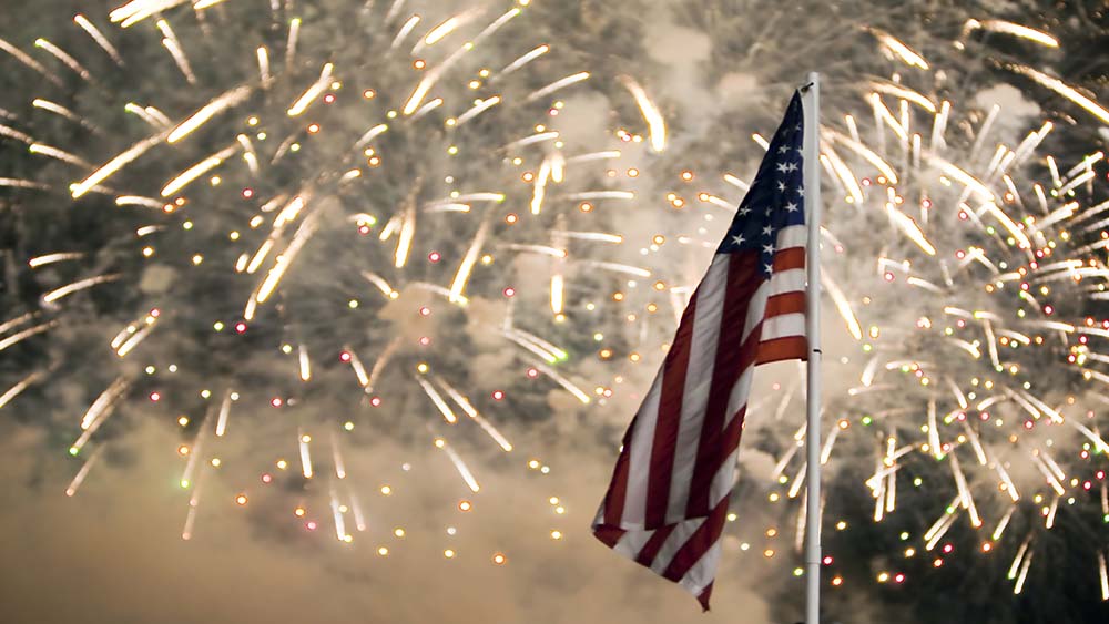 U.S. flag on fireworks-lit sky | 4th of July